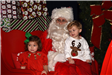 two girls sitting on Santa's lap